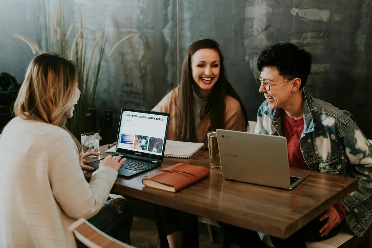 Two people collaborating over laptops — writing Fiverr proposals that win clients